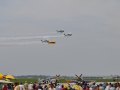 4 T-6 Trainers in the air and 2 P-51 Mustangs on the taxiway
